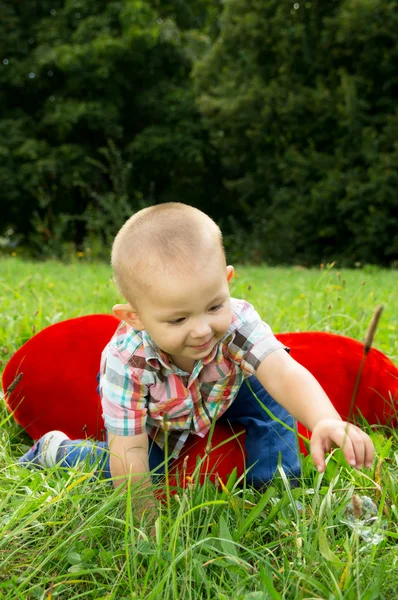 Happy boy sits on heart — Stock Photo, Image