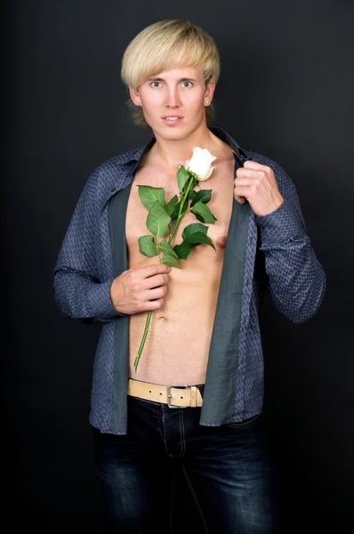 Мускулистый красивый парень с розой в руке — стоковое фото