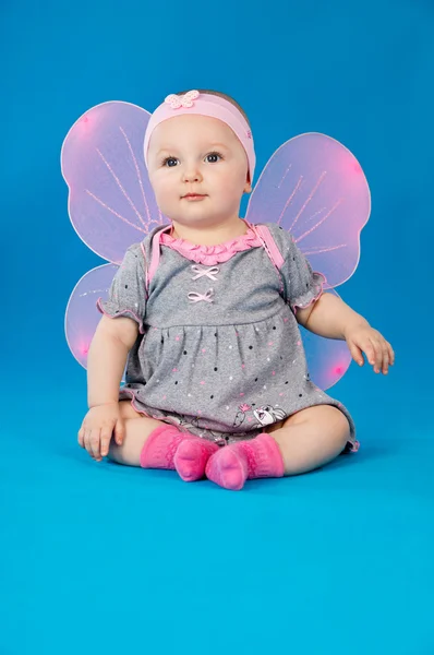 Baby with wings sitting on a blue background — Stock Photo, Image