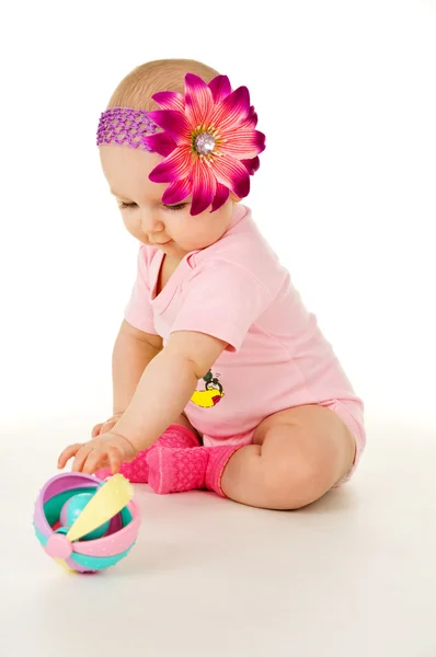 Beautiful baby girl with a flower plays — Stock Photo, Image