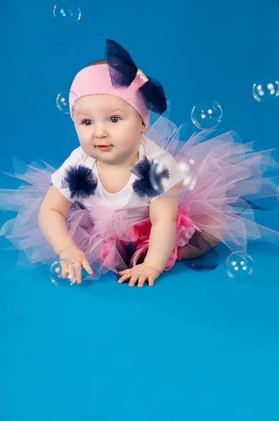 Baby und Seifenblasen auf blauem Hintergrund — Stockfoto