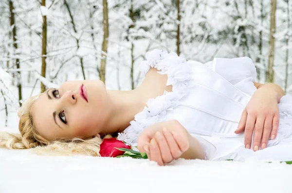 Mädchen im Winterwald mit einer Rose — Stockfoto