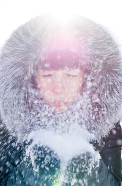 Menina bonita soprando neve — Fotografia de Stock