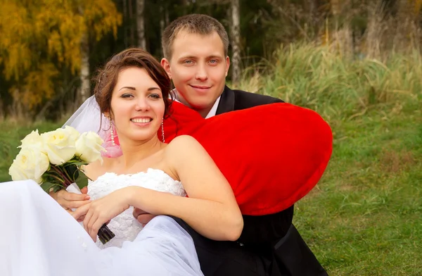 Newlyweds sitting on the grass — Stock Photo, Image