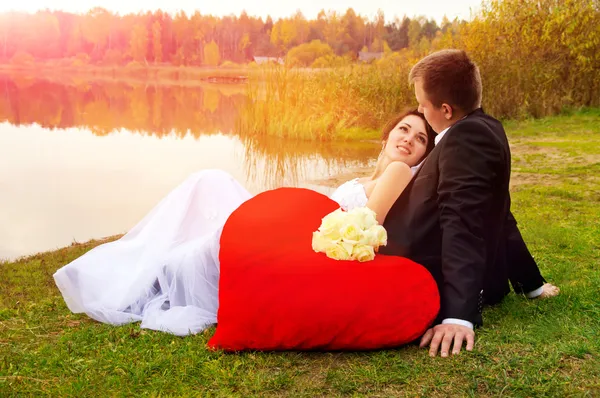 Nowożeńcy, siedząc na trawie — Zdjęcie stockowe