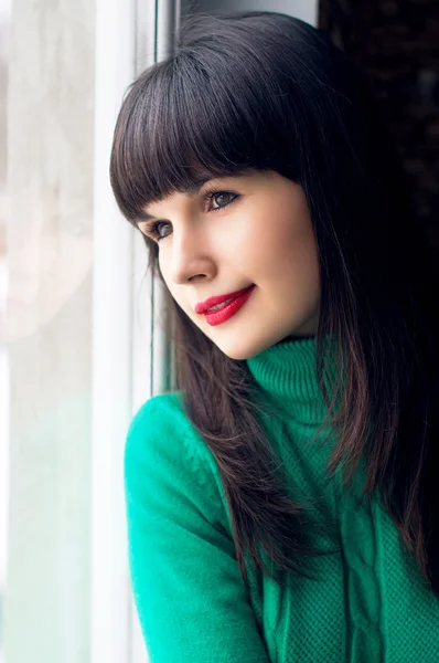 Pretty girl sitting by the window — Stock Photo, Image