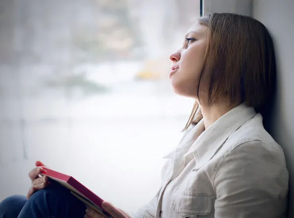 Sad girl looking out the window waiting for her husband — Stock Photo, Image