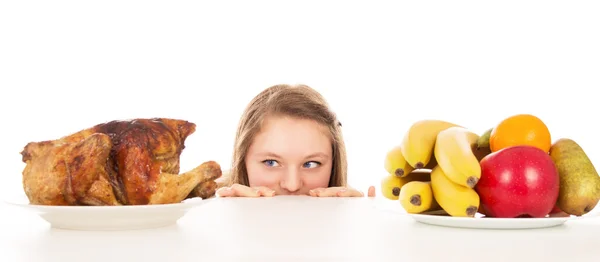 Mooi meisje gluren over de gekookte kip — Stockfoto