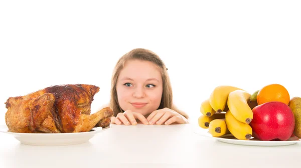 Mooi meisje gluren over de gekookte kip — Stockfoto