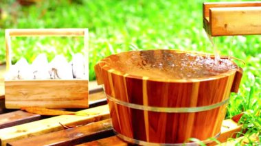 Bahar bahçesinde ayak banyosu için tahta kova, onsen, hafif-odaklı .4k