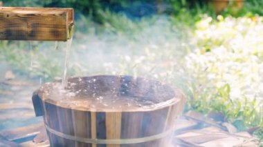 Bahar bahçesinde ayak banyosu için tahta kova, onsen, hafif-odaklı .4k