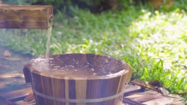 Bahar bahçesinde ayak banyosu için tahta kova, onsen, hafif-odaklı .4k