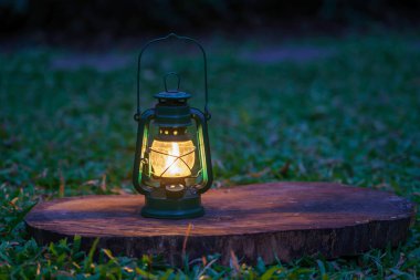Antik gazyağı lambası. Geceleri çimlerin üzerinde lambalar var.
