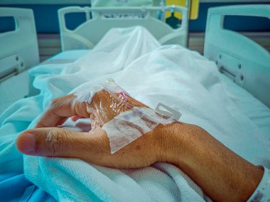 Coronavirus COVID 19 hastasının kolu, serum iğnesi ve hastanın kolundaki ilaç normal tedavi sırasında savaşıyor. Yumuşak odaklanma. Sığ odak etkisi.