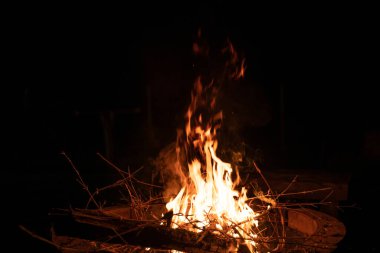 Ateş ve alevler. Alevler ve yanan kıvılcımlar, ateş desenleri. Ateşten gelen alevler. Gece ateşi, odunlar yanıyor, kıvılcımlar uçuşuyor. Yumuşak odaklanma. Sığ odak etkisi.