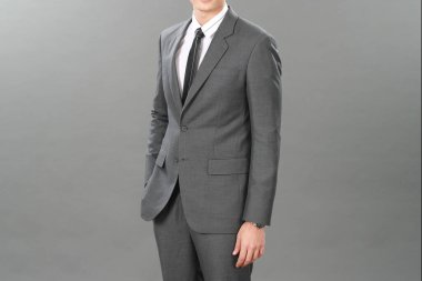 Gri arka planda zarif bir takım giyen bir iş adamı. Stüdyoda iyi giyimli son sınıf öğrencisi. Düşünceli düşünmeyi, dikkatlice düşünmeyi, yumuşak odaklanmayı önemser.