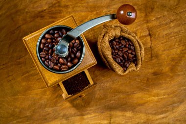 Antika kahve öğütücüsü. Eski el yapımı ahşap ve metal kahve öğütücüsü. Kahve çekirdeklerini öğütmek için el yapımı kahve öğütücü. Eski ahşap arka planda. Yumuşak odaklanma..                      