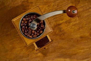 Antika kahve öğütücüsü. Eski el yapımı ahşap ve metal kahve öğütücüsü. Kahve çekirdeklerini öğütmek için el yapımı kahve öğütücü. Eski ahşap arka planda. Yumuşak odaklanma..                      