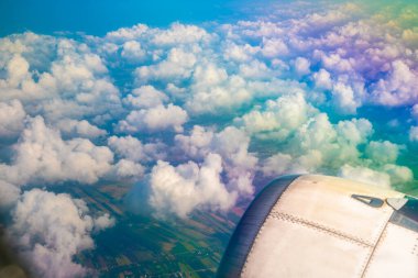 uçuş sırasında uçağın kanatları yolcu penceresinden bakmak. Mavi gökyüzünde beyaz bulutlar var..