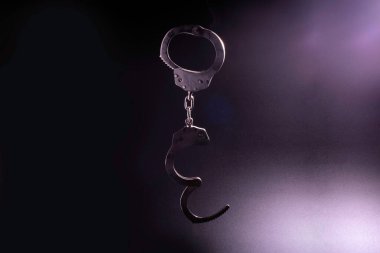 Siyah arka planda kelepçelerin silueti. Yumuşak odaklanma..