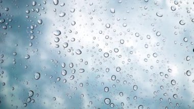 Yağmur damlacıkları alacakaranlıkta arabanın camına yapışır.