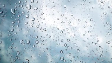 Yağmur damlacıkları alacakaranlıkta arabanın camına yapışır.