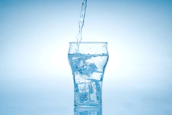 冰块掉进水杯里去了 水从透明的杯子里溅了出来 — 图库照片