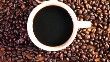 Bardakta sade kahve, eski ahşap zeminde koyu kahve çekirdekleri, kahve çekirdeklerini yakın..