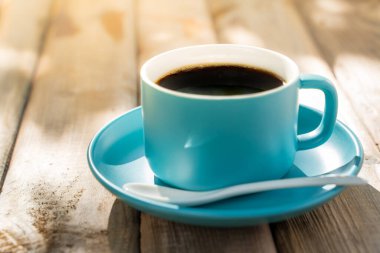 Eski ahşap zeminde mavi seramik kahve fincanı. Yumuşak odaklanma. Sığ odak etkisi.