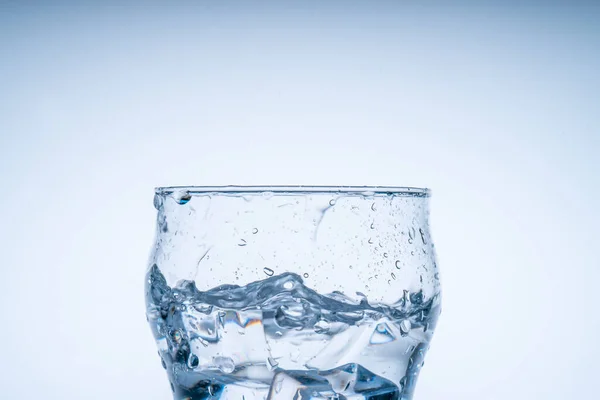 冰块掉进了杯子里 清澈的玻璃杯里喷出水花 新概念 — 图库照片