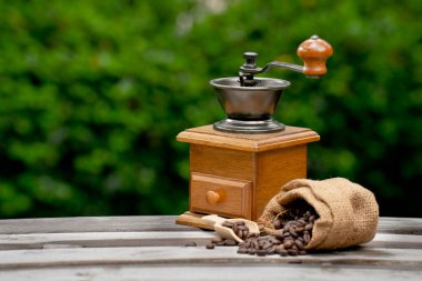 Vintage coffee grinder.Old retro hand-operated wooden and metal coffee grinder.Manual coffee grinder for grinding coffee beans. on the old wooden background.