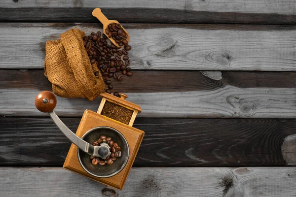 Vintage coffee grinder.Old retro hand-operated wooden and metal coffee grinder.Manual coffee grinder for grinding coffee beans. on the old wooden background.