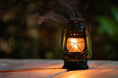 antique kerosene lamp with lights on the wooden floor at night