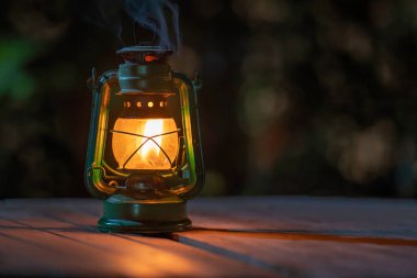 antique kerosene lamp with lights on the wooden floor at night