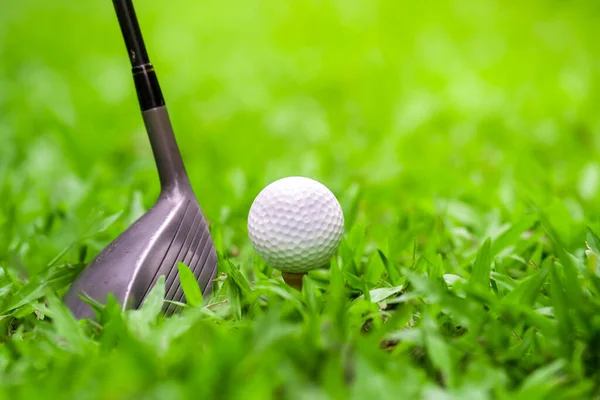 golf club hitting golf ball on green grass