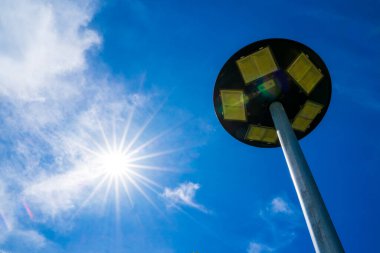 Açık bir günde beyaz bulutlu açık mavi gökyüzü, güneş pili lambası ve güneşten gelen alternatif enerji..