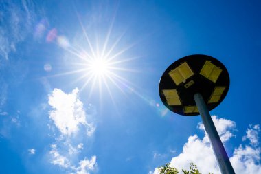 Açık bir günde beyaz bulutlu açık mavi gökyüzü, güneş pili lambası ve güneşten gelen alternatif enerji..