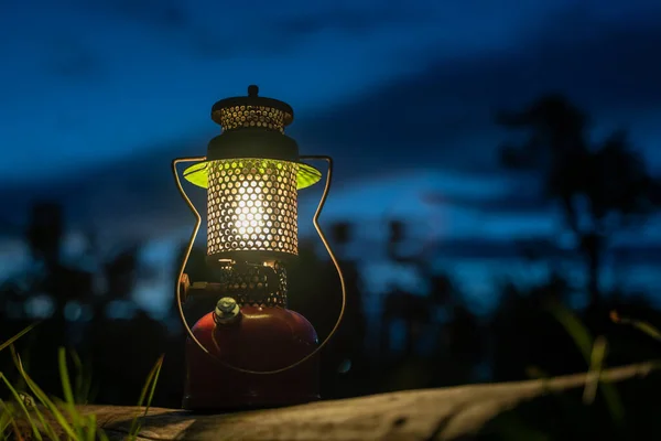 一盏古老的油灯照在一根旧圆木上 夜里在森林里 — 图库照片