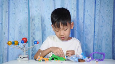 Yoğunlaşmış Asyalı Çocuk Güneş Sistemi Oyuncakları, Evde Öğrenim Malzemeleri