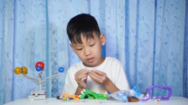 Yoğunlaşmış Asyalı Çocuk Güneş Sistemi Oyuncakları, Evde Öğrenim Malzemeleri