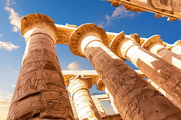 Columns with ancient carvings in the Great Hypostyle Hall of Karnak Temple, Luxor, Egypt.