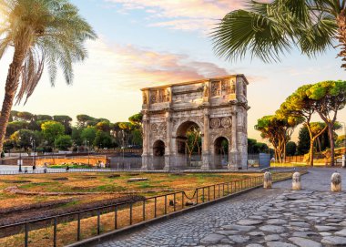 The Arch of Constantine behind the palms, famous place of visit in Rome, Italy.