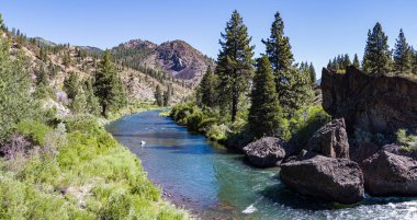 Calm waters flow peacefully through a valley in the California river canyon.
