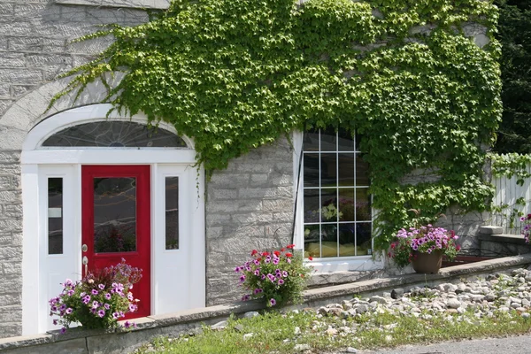 Stone house with red door — Stock Photo, Image