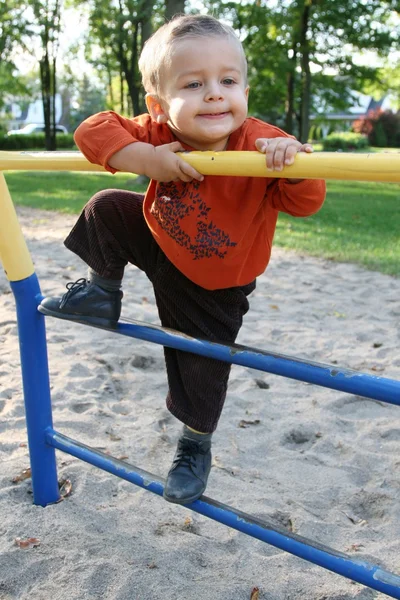 Jongetje speelt in de speeltuin — Stockfoto