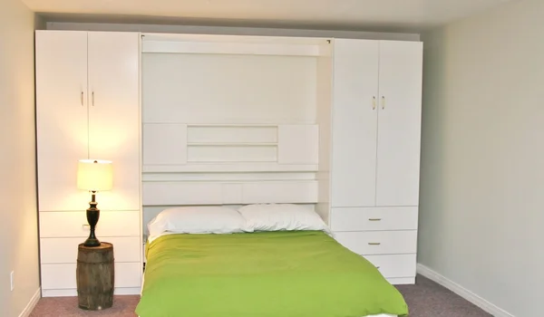 Bed and white headboard and shelves — Stock Photo, Image