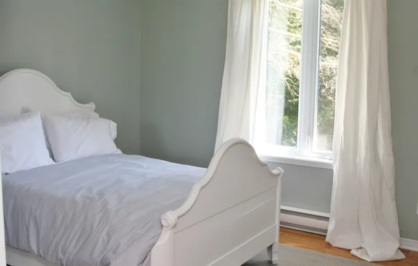 Dormitorio con cama y cortinas — Foto de Stock