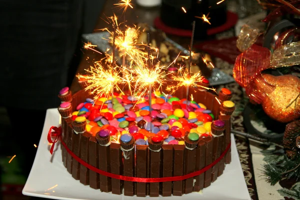 Birthday cake with smarties and sparklers — Stock Photo, Image