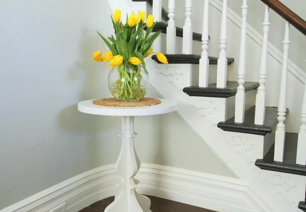 Gele tulpen op een ronde tafel naast erfgoed trap — Stockfoto