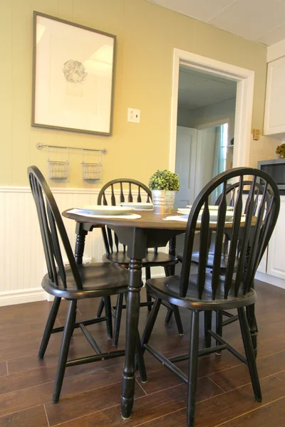 Cocina con armarios blancos y mesa redonda y sillas — Foto de Stock